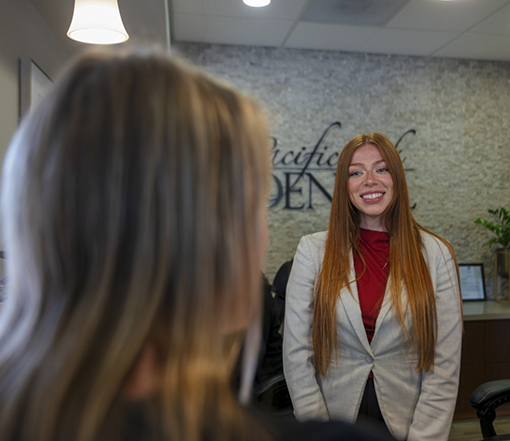 Receptionist smiling at a patient in a Forest Grove dental office