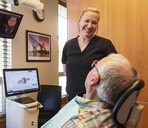 Forest Grove cosmetic dentist smiling at a patient in the treatment chair
