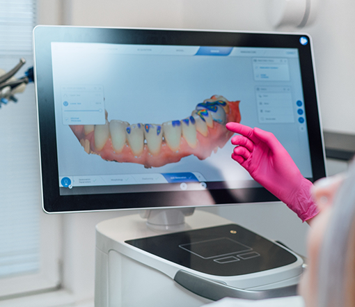 Dentist looking at a screen showing digital scans of a patient's teeth